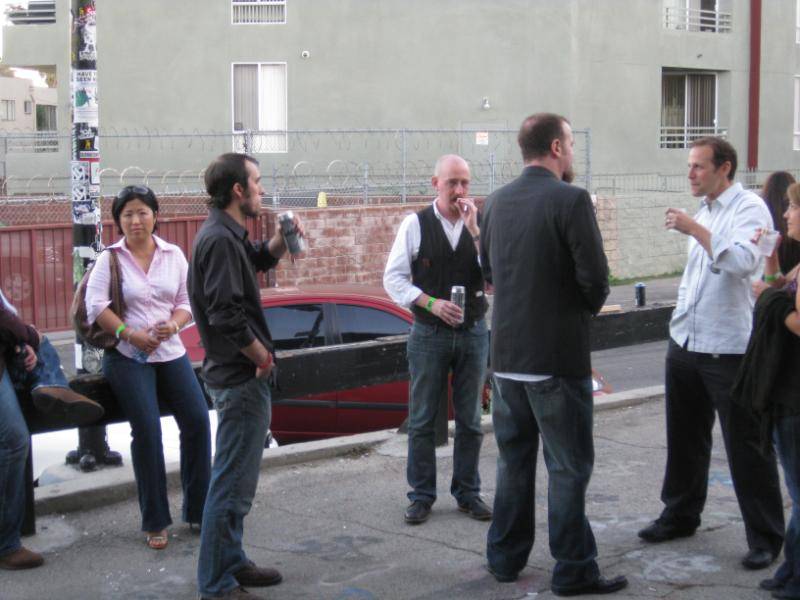 Series writer Brian Azarello smokes a cigar outside.