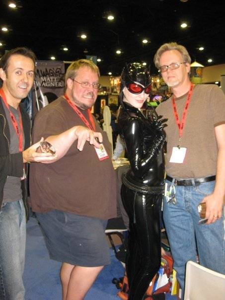 Catwoman posing with 3 of her favorite artists: J. Scott Campbell, Adam Hughes, and Bruce Timm. 