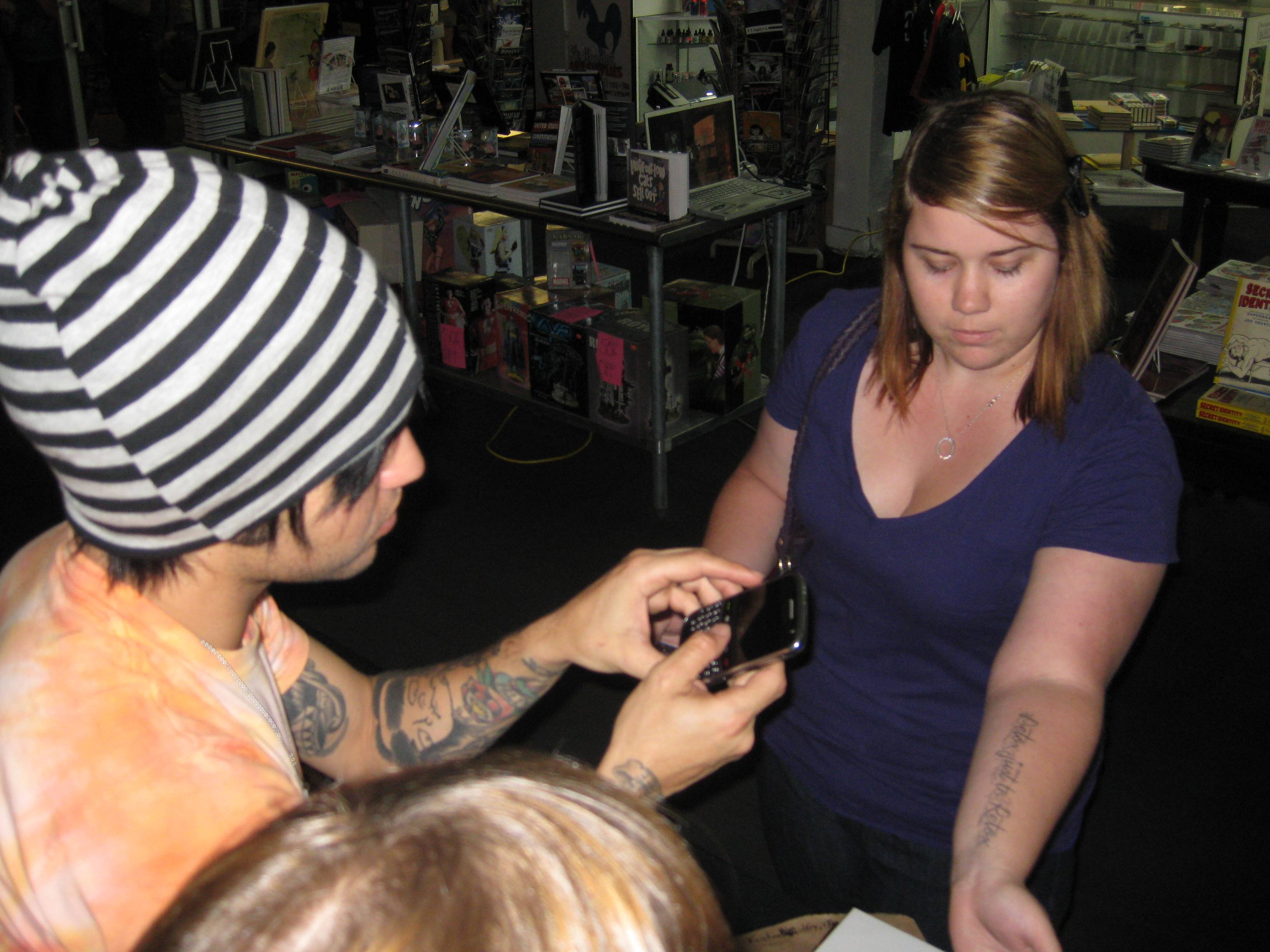 Pete takes a picture of a girl with tattoos of his lyrics.