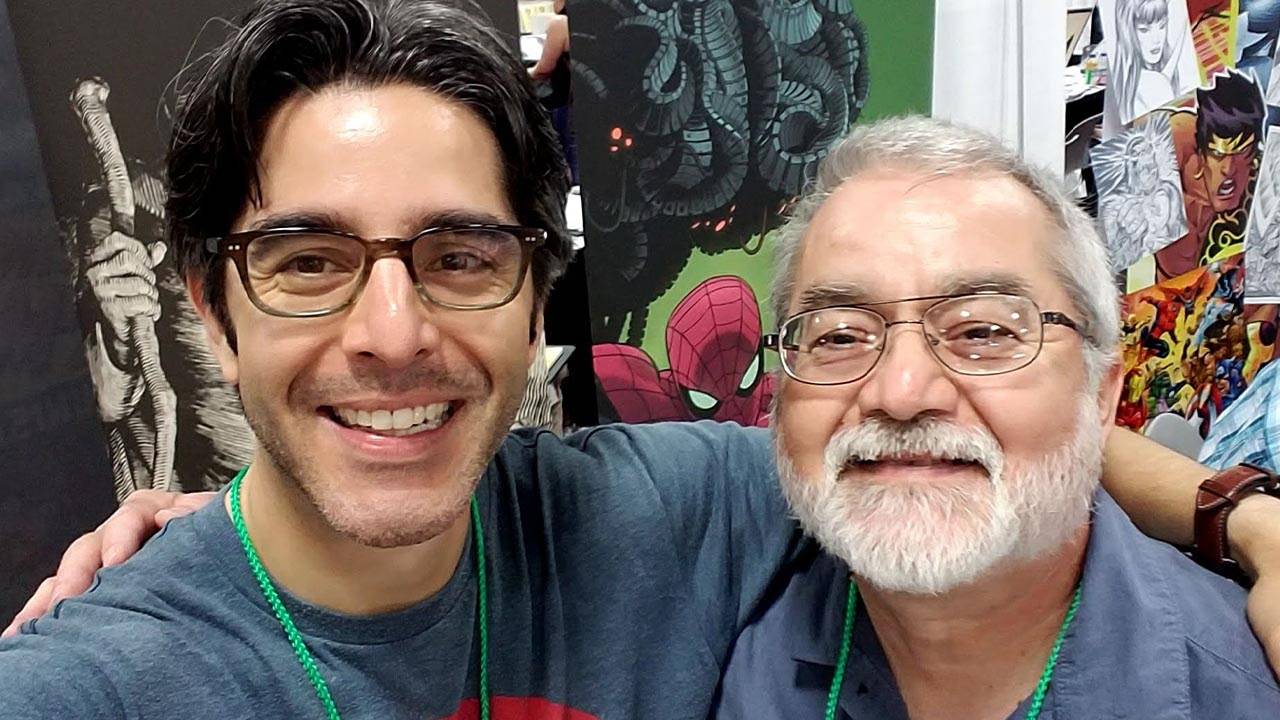 A man with glasses and a comic book is posing for a photo.