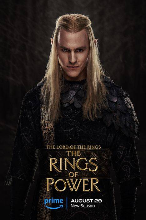 Character with long blond hair and pointed ears in a forest wearing dark, ornate armor with "The Lord of the Rings: The Rings of Power" text and Prime Video logo advertising a new season on August 29.