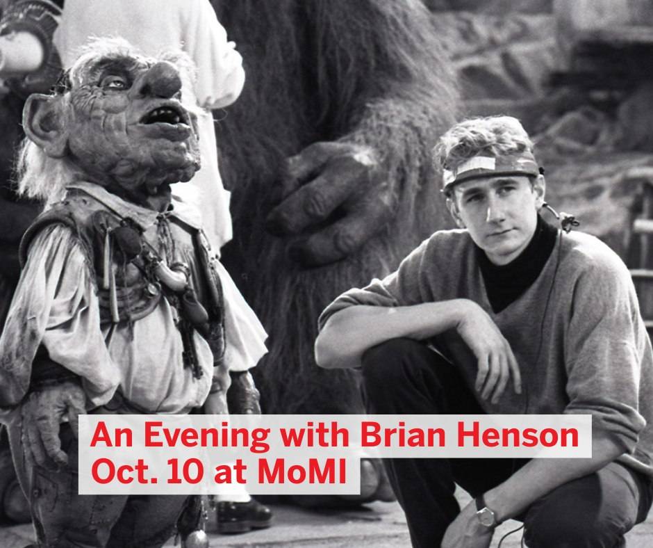 A person sits beside a puppet creature on a set, with text reading, "An Evening with Brian Henson Oct. 10 at MoMI.